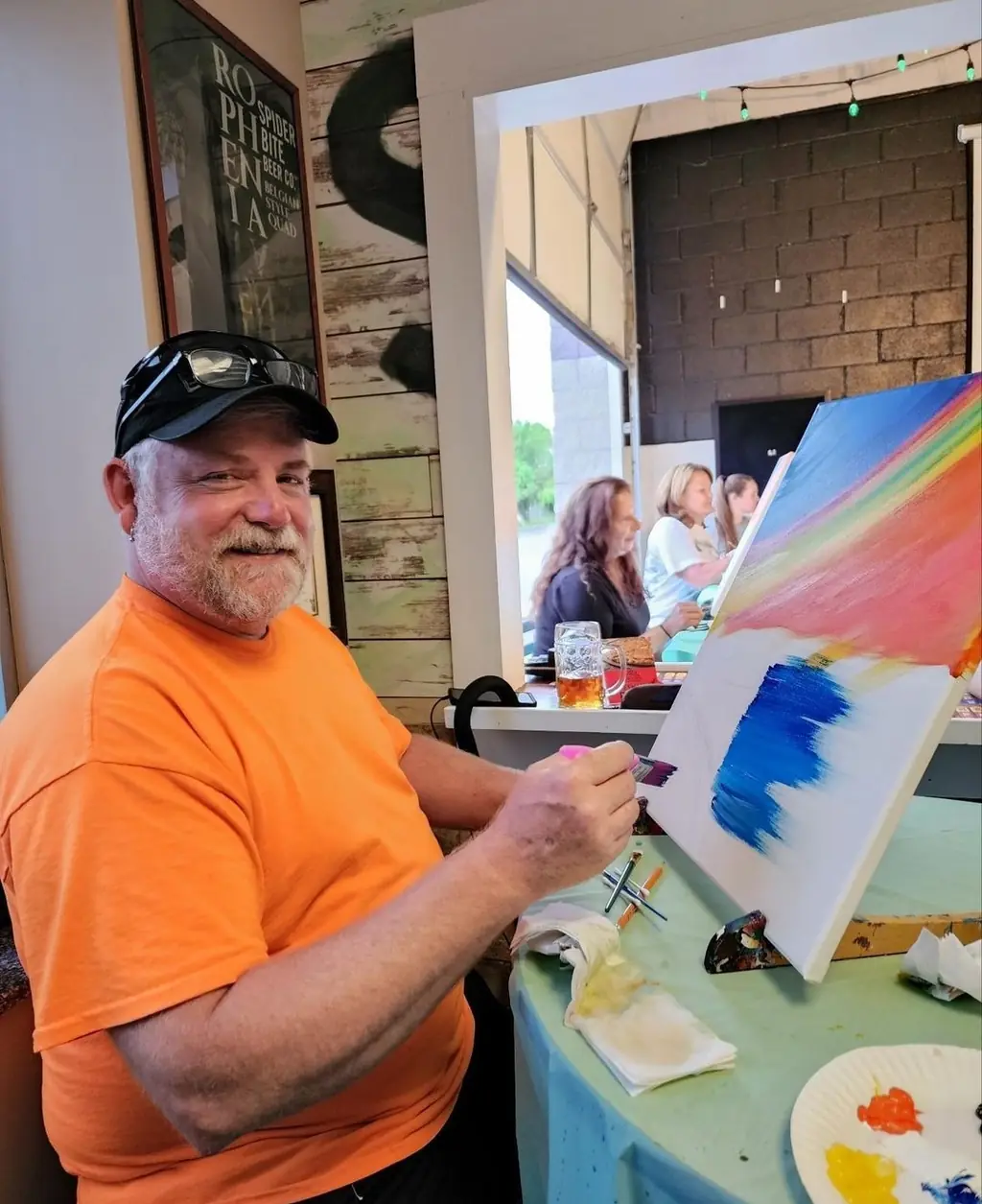 A guest concentrating on his painting at an adult paint night
