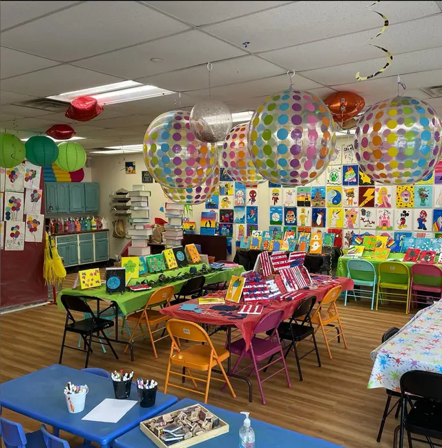 The studio set for a birthday party, with balloons and colorful place settings