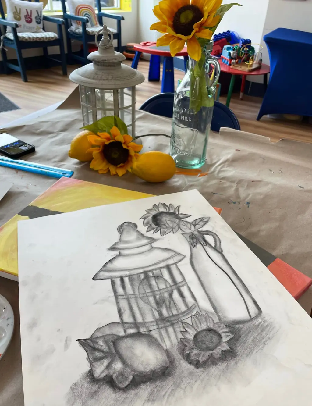 A shaded pencil still-life drawing of a lantern and sunflowers